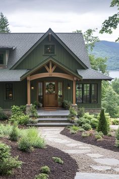 a green house with steps leading to the front door