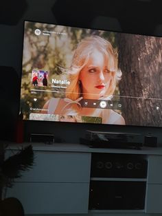 a flat screen tv mounted to the side of a wall next to a plant in a vase