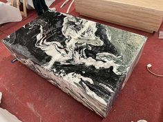 a large marble block sitting on top of a red floor next to a wooden box