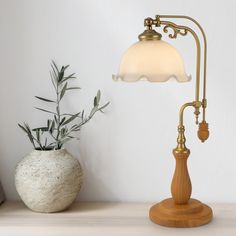 a table lamp next to a potted plant