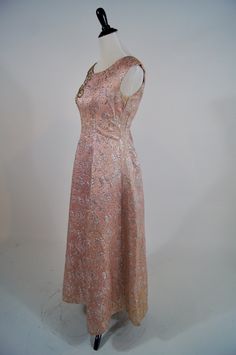 "Wowzers! This vintage 1950s Ann's vogue Shoppe gown is a stunner! It is a full length pink and silver brocade gown with sequin and beaded appliqué on the shoulder. It zips up the back (the original zipper has been replaced) and has a bow at the lower back. It is fully lined in pink acetate and is in excellent condition but does have areas of discoloration in skirt folds and under the arms. Size: M Bust: 34\" Waist: 29\" Hips:Open Length: 52\"" Party Floor-length Brocade Gown, Vintage Floor-length Gown For Gala, Vintage Floor-length Gala Gown, Vintage Brocade Party Dress, Vintage Ball Gown For Gala, Festive Vintage Evening Dress, Pink Brocade Dress For Formal Occasions, Vintage Floor-length Party Gown, Vintage Floor-length Gown For Evening