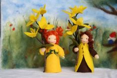 two dolls are holding yellow flowers in their hands