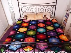 a bed with a colorful quilt on top of it