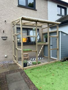 an outdoor area with a chicken coop and grass