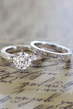 two wedding rings sitting on top of a piece of paper