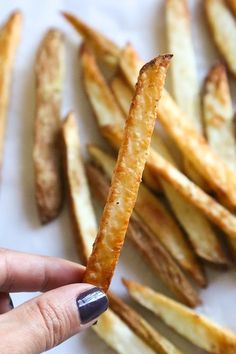 a hand holding up a piece of french fries to show the inside of it's crust