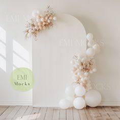 an arch decorated with balloons and flowers in the corner of a white walled room against a wall