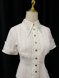 An embroidered blouse that looks like an aristocratic lady from medieval Europe. A cross and a rose are embroidered on the collar, and ivy is also embroidered on the cuffs. The back is decorated with lacework, and the chest is decorated with ruffles, pleats, and lace embroidery. For a young lady with a gorgeous atmosphere. 
 
 

 

 
 
 Color 
 
 White 
 Black 
 
 
 Size 
 
 
 S size 
 
 Length: 60cm 
 Shoulder width: 36cm 
 Bust: 86cm 
 Waist: 68cm 
 Sleeve length: 21.5cm 
 
 M size 
 
 Length: White Fitted Blouse With Lace Sleeves, White Fitted Victorian Blouse, Fitted White Victorian Blouse, Spring Season Gothic Formal Tops, Elegant Short Sleeve Lace Blouse, Fitted Elegant Blouse With Floral Embroidery, White Blouse With Floral Embroidery And Doll Collar, Spring Gothic Formal Blouse, Spring Formal Gothic Blouse