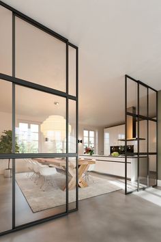 an open kitchen and dining room with glass walls