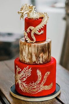 a three tiered red and gold wedding cake