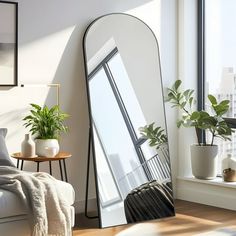 a large mirror in the corner of a living room next to a couch and potted plant