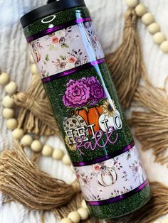 thermos tumbler is decorated with flowers and words on it, along with tassels