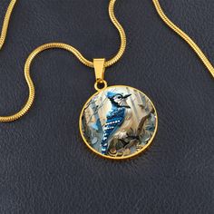 Introducing our exquisite Circle Pendant Necklace, featuring the vibrant blue jay perched gracefully amidst an enchanting woodland. This design captures the blue jay's striking plumage with a mosaic of delicate shades of blue and white, set against a background of softly illuminated trees. Forged from premium surgical steel and available with a lavish 18k gold finish, this innovative jewelry boasts our exclusive design, handcrafted with care right here in the U.S.A by our dedicated team of skilled working mothers. When you choose our necklace, you not only acquire a stunning memento for yourself or a cherished one but also champion the empowerment of working mothers and vibrant communities. Rest assured, your satisfaction is paramount to us, backed by our 100% Happiness Guarantee, ensuring Illuminated Trees, Circle Pendant Necklace, Luxury Necklace, White Set, Blue Jay, Vibrant Blue, Working Moms, Circle Pendant, Gold Finish