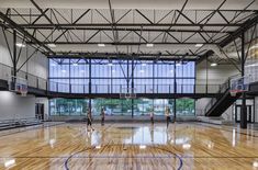 an indoor basketball court with people playing on it