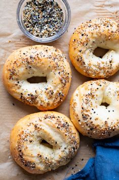 four bagels with poppy seed sprinkles and a bowl of chives