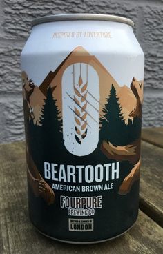 a can of beartooth beer sitting on top of a wooden table next to a wall