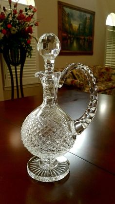 a glass decanter sitting on top of a wooden table