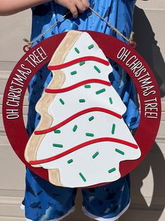 a person holding a sign that says christmas tree and doughnuts are on it