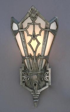 a wall light that has a glass shade on it