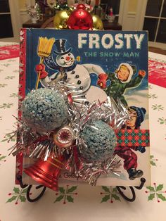 a book sitting on top of a table next to some christmas balls and tinsel