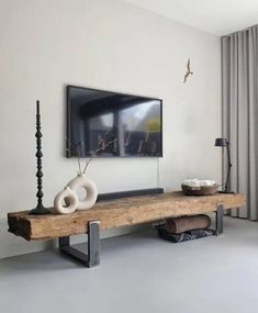 a living room with a large flat screen tv mounted on the wall above a wooden table