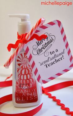 a bottle of hand sanitizer sitting on top of a table next to a red ribbon