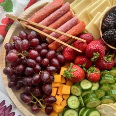 an assortment of fruits and vegetables are arranged on a plate with chopsticks in the middle