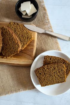 slices of pumpkin spice bread on a wooden cutting board with butter cubes in the background