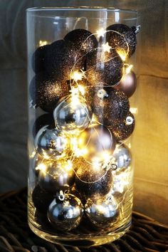 a glass vase filled with ornaments on top of a table