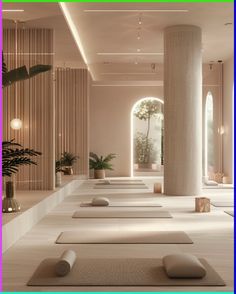 a room filled with lots of white yoga mats and tall columns in front of it