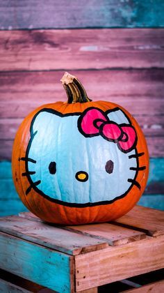 a hello kitty pumpkin sitting on top of a wooden crate