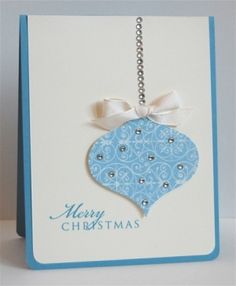 a christmas card with a blue ornament hanging from it's side on a white background