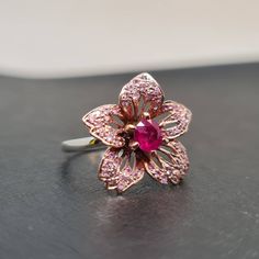 Formal Pink Flower-shaped Rings, Pink Flower Rings In Fine Jewelry Style, Pink Ruby Ring With Rose Cut Diamonds, Pink Ruby Flower-shaped Jewelry, Pink Lab-created Ruby Ring, Flower Shaped Ruby Gemstone Rings, Flower Shaped Ruby Ring As A Gift, Pink Ruby Birthstone Ring For Anniversary, Pink Lab-created Ruby Ring For Gift