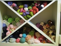 several skeins of yarn are in a white shelf