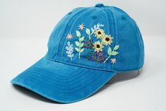 Flower is 100% hand embroidered on a 100% cotton wash black baseball cap. Hat is one size fits all with adjustable back strap. Unique cap, one of a kind! I am also open for customization. If you want the item in different colors, please message me, it will take additional 2-3 days of handling time. Free first class shipping, upgradable priority mail service. 30 days return policy, feel confident at your purchase! Embroidered Blue Spring Hats, Spring Embroidered Blue Hats, Blue Embroidered Spring Hats, Blue Embroidered Curved Brim Hats, Blue Embroidered Baseball Cap For Summer, Blue Embroidered Visor Baseball Cap, Blue Hats With Embroidered Logo For Spring, Embroidered Blue Dad Hat Adjustable, Blue Embroidered Adjustable Dad Hat