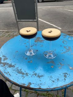 two wine glasses sitting on top of a blue table