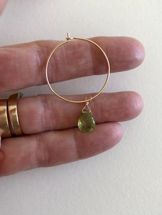 "Lovely apple green genuine peridot pear drops wire wrapped on delicate 1\" 14k gold hoops. Petite faceted peridot briolettes are 7 x 10mm and hang from handmade 1\" 14k gold fill wire hoops. Total drop length is 1 3/4\". Also available in Sterling silver. A lovely sparkly August birthday gift!" Teardrop Peridot Jewelry For Anniversary, Teardrop Peridot Birthstone Jewelry, Teardrop Peridot Jewelry For May Birthstone, Teardrop Hoop Earrings As May Birthstone Gift, Green Peridot Wire Wrapped Jewelry, Green Teardrop Wire Wrapped Jewelry, Gold Teardrop Hoop Earrings For May Birthstone, Gold Teardrop Hoop Earrings With Emerald, Green Wire Wrapped Teardrop Jewelry