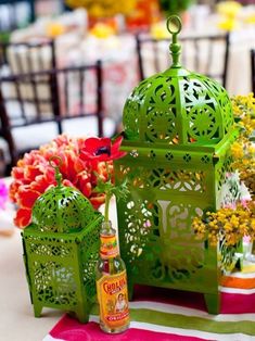 a table topped with green lanterns and flowers