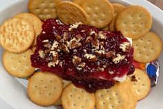 a plate with crackers and cranberry sauce on it next to crackers