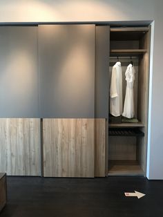 an open closet with clothes hanging on the wall