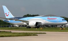 a blue and white plane is on the runway