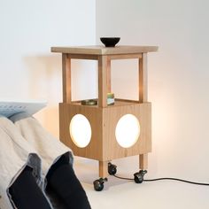 a light that is sitting on top of a wooden stand next to a laptop computer