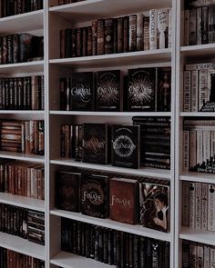 a book shelf filled with lots of books on top of white shelving unit units