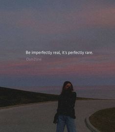 a woman standing on the side of a road next to the ocean with a quote above her that reads, be imperfectedly real, it's perfectly rare