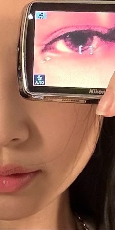 a close up of a person holding a cell phone with an eye on the screen