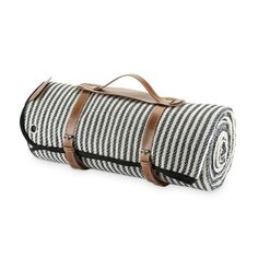 a black and white striped blanket with brown leather straps on the bottom, in front of a