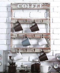 there is a coffee cup rack on the wall with cups hanging from it's hooks