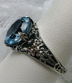 Excited to share the latest addition to my #etsy shop: 4ct Oval Natural Sky Blue Topaz Sterling Silver Victorian Floral Leaf Filigree Ring (Made To Order) Design #62 https://etsy.me/2oUxOoS #jewelry #ring #sterling #silver #no #yes #girls #blue #topaz Antique Oval Topaz Ring With Filigree, Antique Blue Topaz Ring With Center Stone, Antique Oval Topaz Jewelry, Elegant Sapphire Filigree Ring In Oval Shape, Elegant Sapphire Oval Filigree Ring, Elegant Sapphire Filigree Ring With Oval Shape, Elegant Oval Sapphire Filigree Ring, Oval Topaz Ring With Gemstone Accents For Wedding, Classic Oval Blue Topaz Filigree Ring