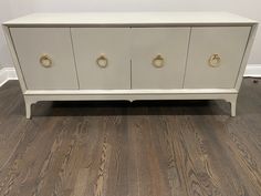 a white and gold dresser with brass handles