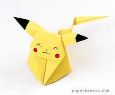 an origami pikachu with red eyes and black horns on it's head